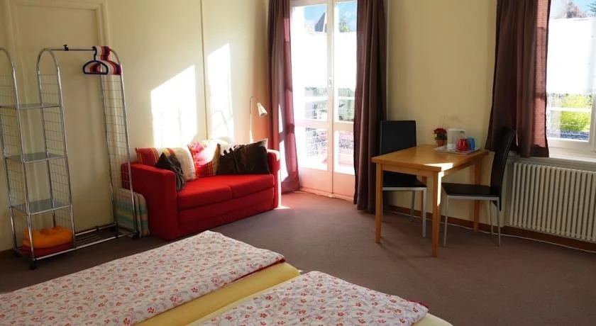 Guest room with red sofa and seating corner