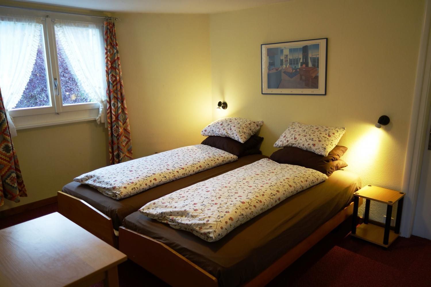 Guest room with twin beds and wooden furniture